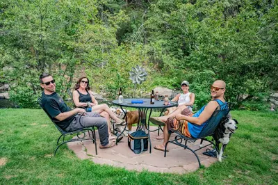 a group of people sitting around a table in the grass at Colorado Bear Creek Cabins in Evergreen