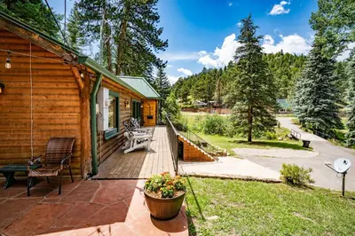 a wooden deck with a bench and a house at Colorado Bear Creek Cabins in Evergreen