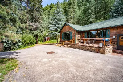 a cabin in the woods with a large driveway at Colorado Bear Creek Cabins in Evergreen