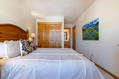 a bedroom with a large bed with a wooden headboard at 2640 Tenderfoot Lodge Condo in Keystone