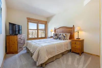 a bedroom with a large bed and a television at 2640 Tenderfoot Lodge Condo in Keystone