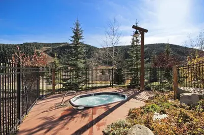 a hot tub on a patio with a fence at 2640 Tenderfoot Lodge Condo in Keystone
