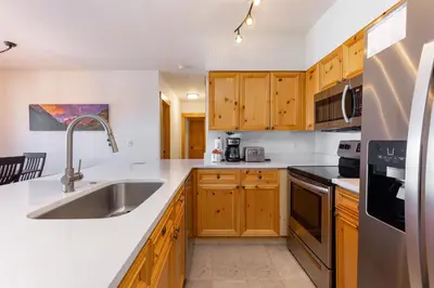a kitchen with wooden cabinets and a sink at 2640 Tenderfoot Lodge Condo in Keystone