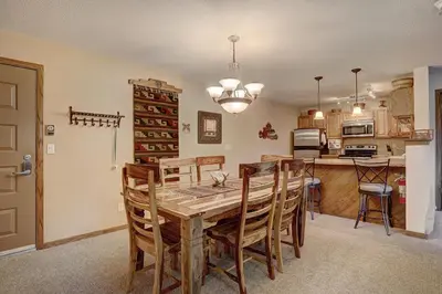 a kitchen and dining room with a wooden table and chairs at 204 Snowdance Manor Condo in Keystone