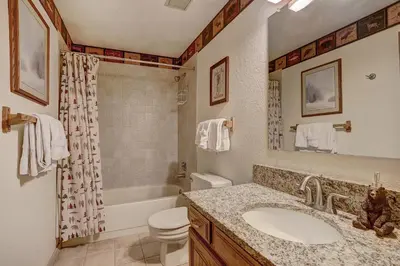 a bathroom with a sink and a toilet and a tub at 204 Snowdance Manor Condo in Keystone