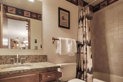 a bathroom with a toilet and a sink and a mirror at 204 Snowdance Manor Condo in Keystone