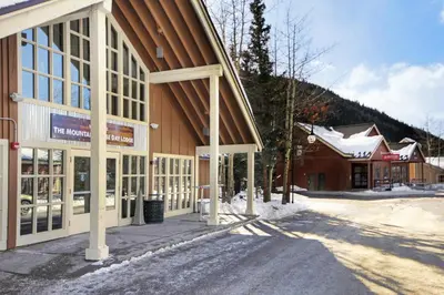 a building with snow on the ground in front of it at 204 Snowdance Manor Condo in Keystone