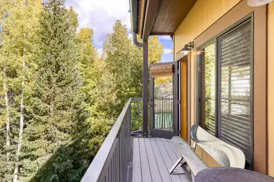 a balcony with a bench and a view of trees at Penthouse 2796 Slopeside Ski In Ski Out Condo in Keystone