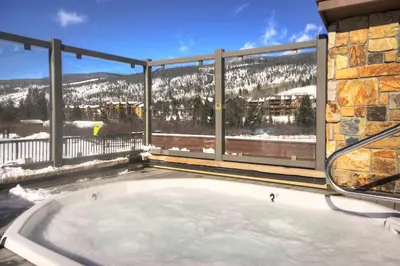 a hot tub on a balcony with a mountain view at Penthouse 2796 Slopeside Ski In Ski Out Condo in Keystone