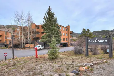 a sign in front of a key combo building with a pine tree at 2964 Key Condo in Keystone