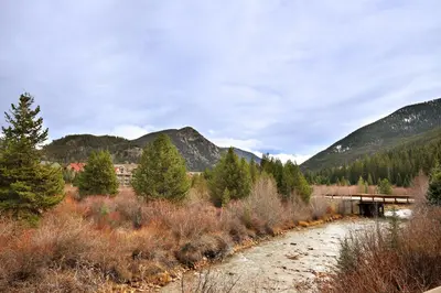 a bridge over a dirt road with mountains in the background at 2964 Key Condo in Keystone