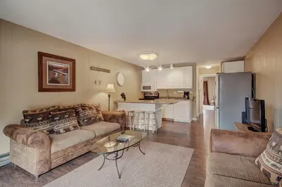 a living room with a couch and a table and a kitchen at 2964 Key Condo in Keystone