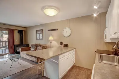 a kitchen and living room with a clock on the wall at 2964 Key Condo in Keystone