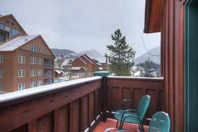 a balcony with two chairs and a snow covered mountain at River Run Mill Creek Combo Condo in Keystone