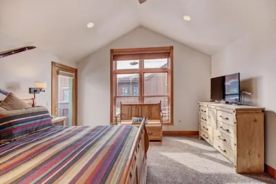 a bedroom with a bed and a tv and a window at River Run Mill Creek Combo Condo in Keystone