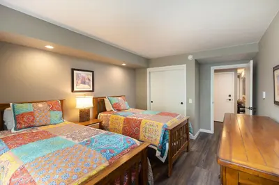 a bedroom with two beds and a wooden table at 2112 The Pines Condo in Keystone