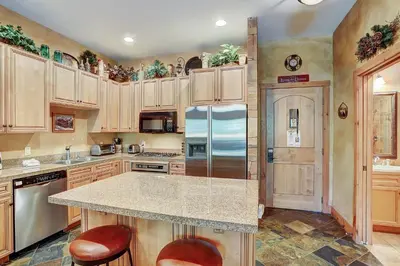 a kitchen with wooden cabinets and a refrigerator at 3056 The Timbers Condo in Keystone
