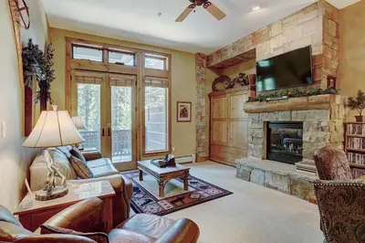a living room with a fireplace and a flat screen tv at 3056 The Timbers Condo in Keystone