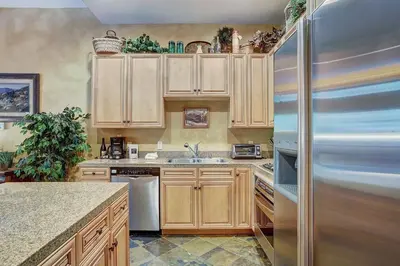 a kitchen with wooden cabinets and a refrigerator at 3056 The Timbers Condo in Keystone