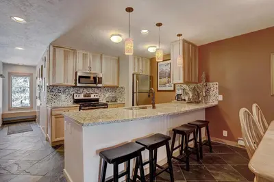 a kitchen with a counter and some stools in it at 2065 The Pines Condo in Keystone