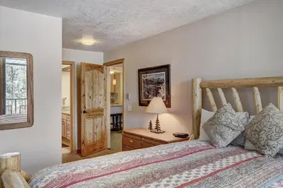 a bedroom with a bed with a wooden headboard at 2065 The Pines Condo in Keystone