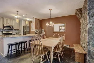 a kitchen and dining room with a wooden table and chairs at 2065 The Pines Condo in Keystone