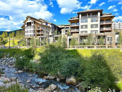 a large apartment building next to a river at 4368 Founders Pointe Cozy WP Village Condo in Winter Park