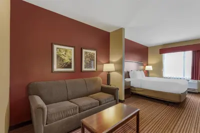 a hotel room with a couch and a bed at Best Western Plus Hudson Hotel & Suites in Hudson