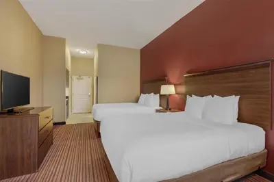a hotel room with two beds and a flat screen tv at Best Western Plus Hudson Hotel & Suites in Hudson