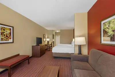 a hotel room with a bed and a couch at Best Western Plus Hudson Hotel & Suites in Hudson