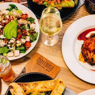 a table with plates of food and a glass of wine at Le Meridien Denver Downtown in Denver
