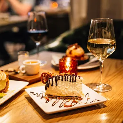 a table with a piece of cake and a glass of wine at Le Meridien Denver Downtown in Denver