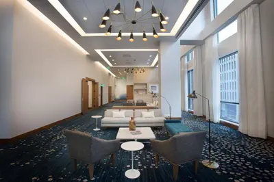 a lobby with couches and chairs in a building at Le Meridien Denver Downtown in Denver