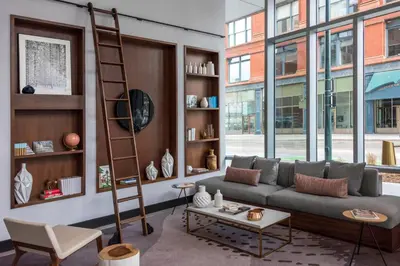 a living room with a couch and a ladder at Le Meridien Denver Downtown in Denver