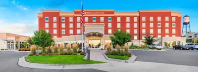 a large red building with a flag in front of it at Hilton Garden Inn Arvada/Denver, CO in Arvada