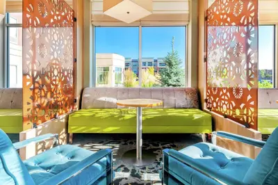 a room with a table and chairs and a window at Hilton Garden Inn Arvada/Denver, CO in Arvada