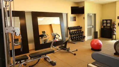 a gym with a mirror and some exercise equipment at Hilton Garden Inn Arvada/Denver, CO in Arvada