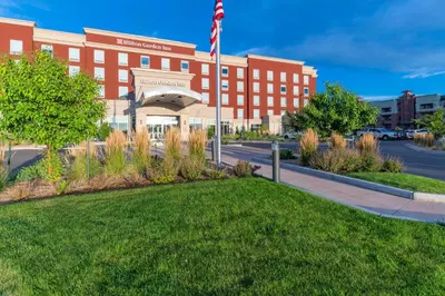 a red brick building with an american flag in front at Hilton Garden Inn Arvada/Denver, CO in Arvada