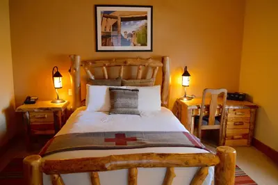 a bedroom with a wooden bed with two tables and two lamps at Niwot Inn & Spa in Niwot