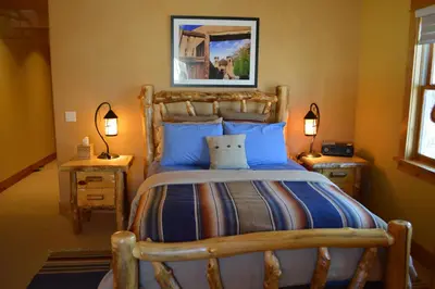 a bedroom with a large wooden bed with blue pillows at Niwot Inn & Spa in Niwot