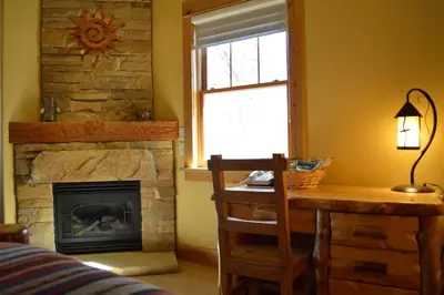 a room with a desk and a fireplace at Niwot Inn & Spa in Niwot