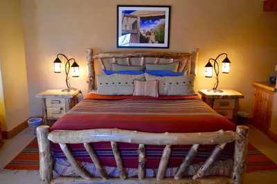 a bedroom with a large wooden bed with two lamps at Niwot Inn & Spa in Niwot