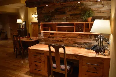 a room with a stone wall and a desk with chairs at Niwot Inn & Spa in Niwot