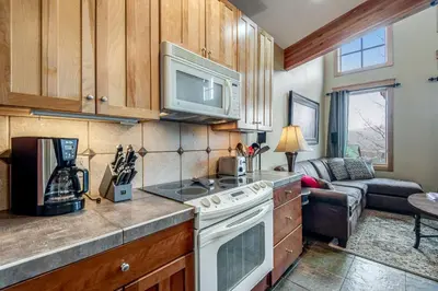 a kitchen with a stove top oven next to a living room at Dillon Ridge Retreat in Dillon