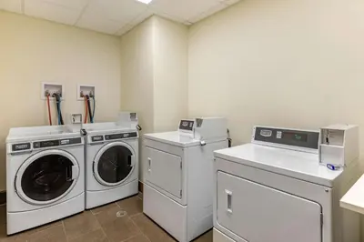a laundry room with a washer and dryer at MainStay Suites Near Denver Downtown in Denver