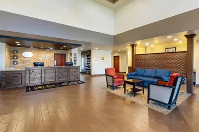 a living room with a blue couch and chairs at MainStay Suites Near Denver Downtown in Denver