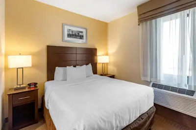 a hotel room with a large bed and a window at MainStay Suites Near Denver Downtown in Denver