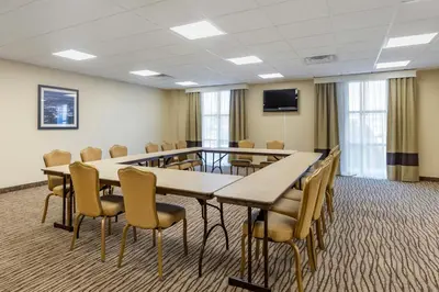 a conference room with tables and chairs and a tv at MainStay Suites Near Denver Downtown in Denver
