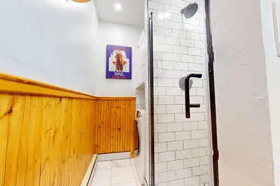 a bathroom with a shower and a tile wall at Meadow Creek in Frisco