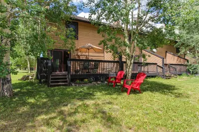 two red chairs sitting in front of a house at Meadow Creek in Frisco
